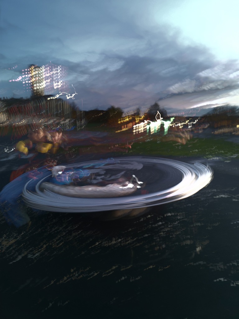 A playground roundabout painted in light as it whizzes past